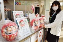 店内カウンターにだるまを並べる職員