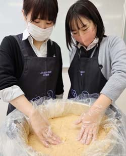 「自家製味噌」を保存容器に詰める職員(長野県茅野市で)