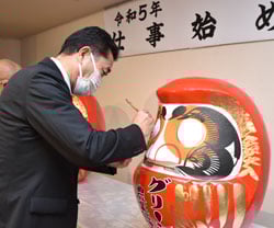 だるまに目を入れ祈願する栗林組合長
