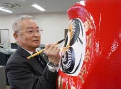 だるまに目を入れる小松組合長