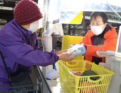 粗品を受け取る買い物客