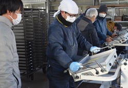 専用の播種機でセルトレイへ種をまく組合員