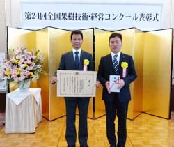 表彰状を授与された月岡部会長（左）と志賀高原ブロックの徳竹地区担当理事