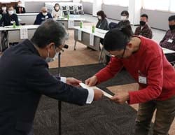 田中学長（左）から修了証を受け取る辻本さん