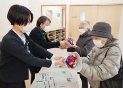事務局がアネモネの花束を手渡した