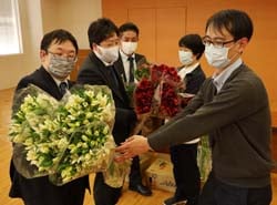 花束を贈る三浦委員長（左）ら