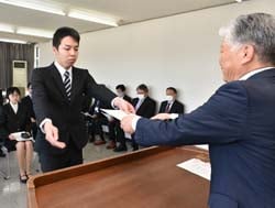 千國組合長（右）から辞令を受け取る新採用職員（左）