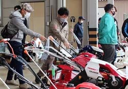 担当者から農業機械の説明を受ける来場者
