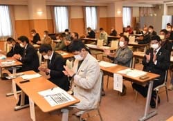 拍手で議案を承認する会場