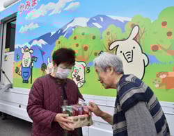 アクリルたわしを利用者に手渡す北原さん