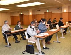拍手で議案を承認する会場