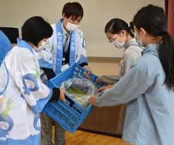 アスパラガスを手渡すJA職員（左）と代表して受け取る児童