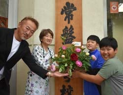 常盤小学校の児童へシャクヤクを贈る女性部みゆき地区の足立さんとみゆき花き共撰部会の太田さん