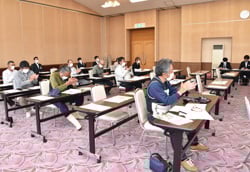 拍手で議案を承認する会場