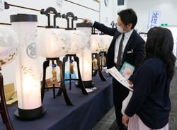 担当者の説明を熱心に聞く見学者（4日　長野県松本市で）