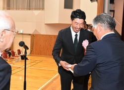 ：功績を称え記念品を渡す千國組合長（右）と安田さん（中央）、河崎委員長（左）
