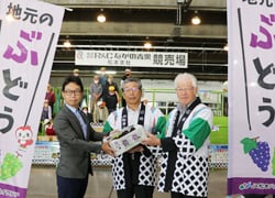 「デラウェア」を手渡す田中組合長（中）と三村常務理事