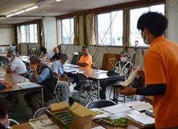 ふき取り方の実演を確認する参加者