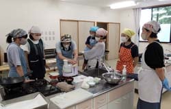 フードプロセッサーで材料を混ぜる参加者