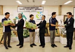 JA役員から同チーム関係者に地元農産物を手渡した贈呈式