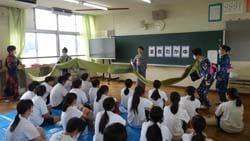 反物を広げて見せる着物を愛する会のメンバー