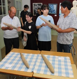 制作を担当した生徒（中央2人）と完成したナガイモ模刻を確認する中川部会長（右）