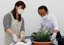 講師に寄せ植えのポイントを教わる部会員（左）