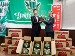 すいかを手渡す田中均組合長（右）
