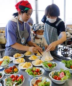 料理を盛り付ける参加者