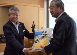 伊那華の米を手渡す西村組合長（右）と受け取る白鳥市長（左）（長野県伊那市で）