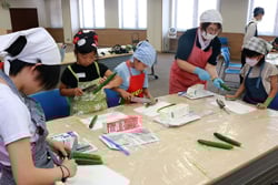 くるくるキュウリづくりを体験する子供たち
