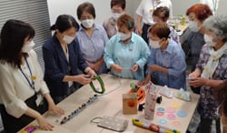 掲載手芸の作り方を熱心に聞く女性部員
