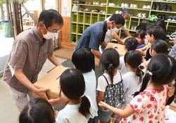 園児にモモを渡すもも部会篠ノ井支部生産者