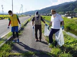 道路わきや河岸のごみを拾い集める参加者