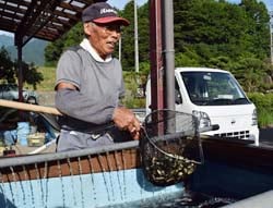 最高の出来の小ブナを網ですくう竹花さん