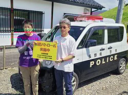 交番横で看板を掲げる部会長と副部会長