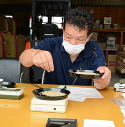 米を検査する飯沼さん