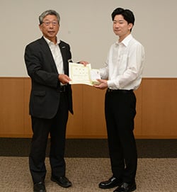 田中組合長（左）から認定書と支援金を受け取る百瀬さん