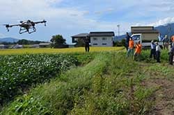 ドローンの実演を見学する出席者