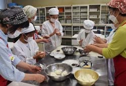 女性部員と一緒におはぎ作りを楽しむ児童ら