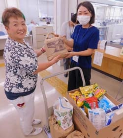 集まった食品を社会福祉協議会職員へ手渡す久保部長