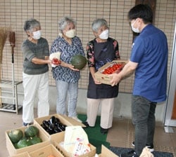古屋さん（右）に集まった品物を受け渡す支部役員