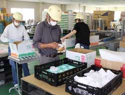 丁寧に検品・荷造りをする施設利用者ら