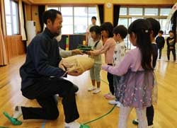 園児に新鮮な野菜を手渡す部員