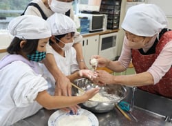 児童におやき作りを教える女性部員