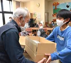 施設利用者（左）に古布を寄贈する白坂委員長（右）