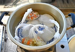 皿を敷き、食材などを湯せん（24日長野県大町市で）