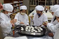 団子を焼く児童