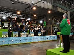 「サンふじ」の出来栄えをPRする西牧部会長（右）と仲卸業者ら（松本市笹賀）