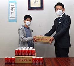 部長の山﨑さんにリンゴジュースを手渡す清水部長（右）